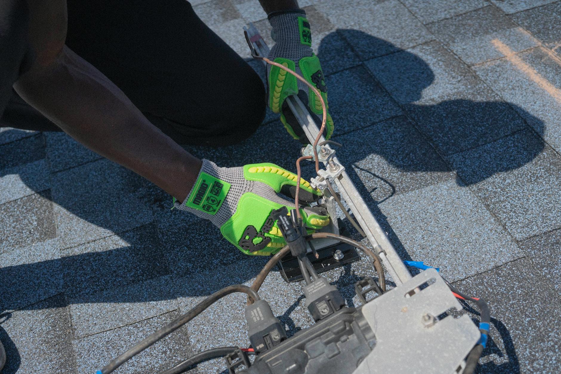 A professional roofer from Iron Star Roofing inspecting a residential roof in a Braintree neighborhood, pointing out details to a homeowner while discussing options.